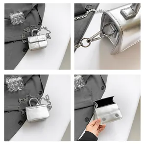 Detail of silver crocodile-embossed mini bag featuring chain strap and magnetic closure