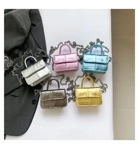 Detail shot of mini crocodile pattern bags in silver, pink, blue, gold and bronze finishes