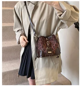 Détail du sac seau léopard avec garnitures en cuir verni brillant et fermeture à cordon