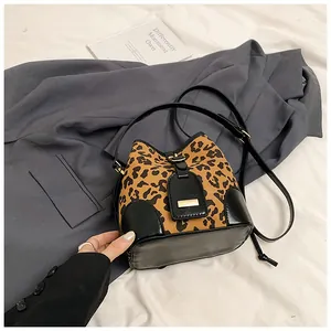 Détail du sac seau léopard avec finitions en cuir noir et bandoulière réglable