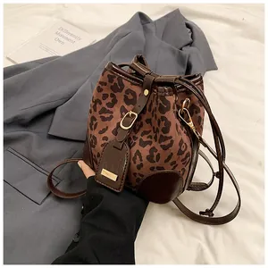 Vue détaillée du sac seau léopard avec cordon en cuir et finitions métalliques dorées