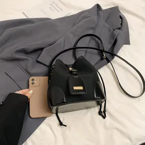 Sac seau vintage noir en toile et cuir avec cordon de serrage et détails en métal doré