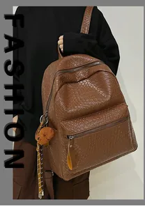 Detail eines dunkelbraunen Web-Rucksacks mit großem Hauptfach und Plüschbär-Anhänger