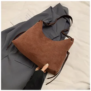Detailed view of brown matte suede Hobo bag with side tassels and gold ring hardware