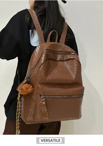 Detail eines braun gewebten Lederrucksacks mit Plüschbär-Anhänger auf einem Modell