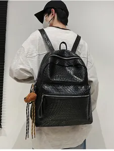 Detail eines schwarzen Rucksacks mit Webstruktur und süßem braunem Plüschbär-Anhänger