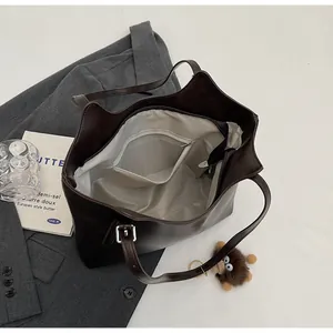 Detail view of large dark brown leather tote with inner zipper pocket and gray lining