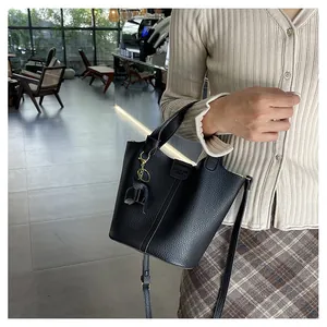 Detail der schwarzen Beuteltasche mit Kieselleder und Elefantenanhänger im Café-Stil