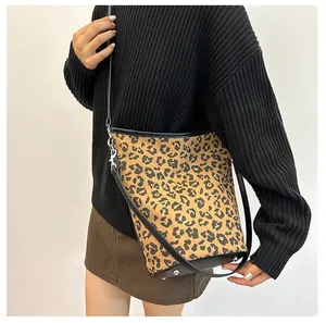 Vue détaillée du sac seau léopard avec rivets de protection argentés et fond en cuir noir