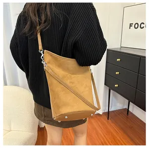 Détail du sac seau en daim marron avec clous de protection en métal argenté au fond