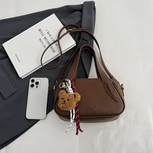 Retro dark brown litchi pattern leather handbag with plush bear charm and shoulder strap