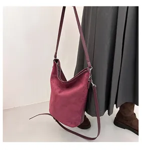 Détail du sac bandoulière en daim bordeaux avec ferrures argentées et sangle en cuir