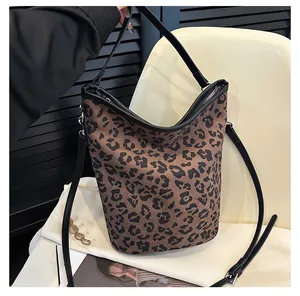 Détail du sac seau à imprimé léopard avec fermeture éclair et bandoulière en cuir