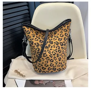 Détail du sac seau à motif léopard avec finitions en cuir noir et boucles métalliques
