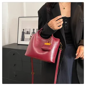 Borsa a secchiello in pelle bordeaux con mini charm coordinato e tracolla regolabile