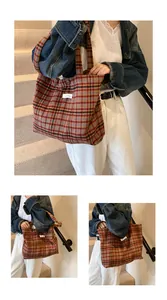 Macro view showing vintage plaid tote bag texture and detailed white fabric logo patch