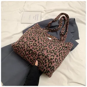 Close-up of leopard print tote bag with soft plush texture and stylish brown button closure