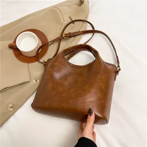 Borsa a mano retrò marrone caramello con tracolla in un contesto di lifestyle