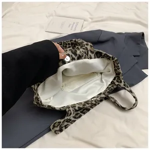Close-up of leopard print plush tote bag showing magnetic closure and interior zipper pocket
