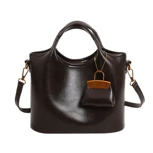 Borsa tote in pelle cerata marrone scuro con mini ciondolo e tracolla regolabile