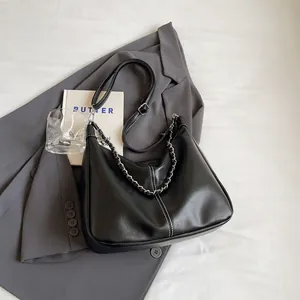 Minimalistische schwarze Leder-Einkaufstasche mit weißen Kontrastnähten und Silberkette