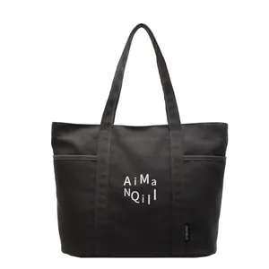 Borsa tote minimalista in tela nera con stampa bianca e tasche laterali da donna