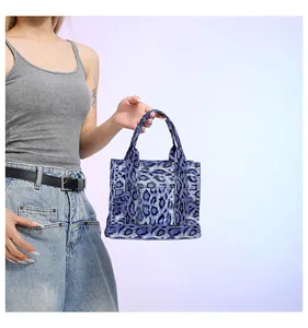 Detail of blue leopard print handbag featuring double handles and front pocket