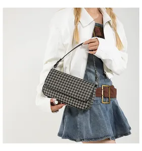 Detail der Houndstooth-Achseltasche mit schwarzen Lederbesätzen und elegantem Schultergurt