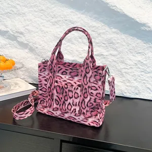 Pink leopard print canvas tote bag with crossbody strap and external pocket