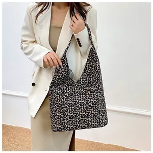 Detailed view of the large leopard print canvas tote bag worn over the shoulder