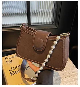 Détail du sac à bandoulière en patchwork marron avec anse en perles et bandoulière