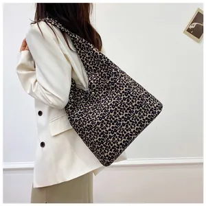 Detail of leopard print canvas tote bag featuring magnetic closure and wide strap