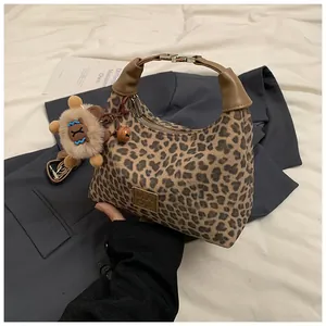 Détail du sac hobo léopard avec poignée en cuir marron et breloque peluche mignonne