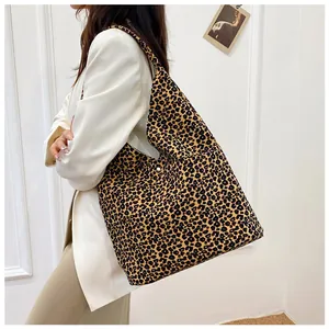 Detail of leopard print canvas tote bag featuring silver snap button and wide strap