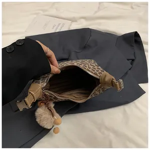 Vue intérieure du sac à main léopard avec doublure rayée et poche zippée détaillée
