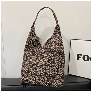 Detail shot of leopard print canvas tote bag with magnetic snap closure and wide strap