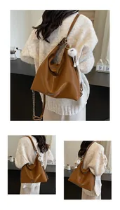 Vue détaillée du sac cabas en cuir marron avec chaîne en métal et breloque en peluche