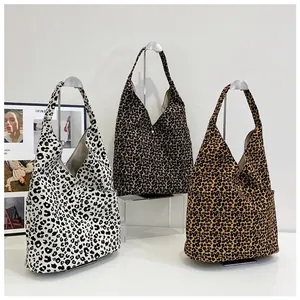 Three leopard print canvas tote bags in different shades displayed on silver stands