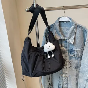 Lightweight black nylon crossbody bag with drawstring design and white cloud charm
