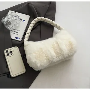 Detail of white faux fur handbag with a braided cream leather strap on a grey suit