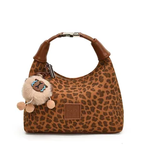 Sac hobo à motif léopard avec poignées en cuir et breloque peluche sur fond blanc