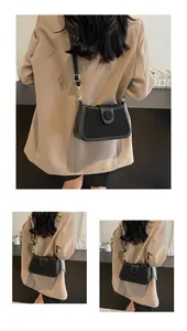 Détail du petit sac bandoulière en cuir noir avec boucle décorative ronde chic
