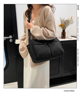 Détails du sac bandoulière en nylon noir avec deux poches zippées et bandoulière large
