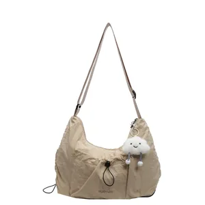 Minimalist beige nylon crossbody bag with drawstring pocket and a cute cloud charm