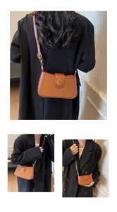Détail de la texture du cuir marron et de l'élégante bandoulière en chaîne du sac