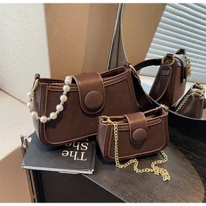 Vue détaillée du sac à bandoulière marron avec bandoulière en perles et chaîne dorée