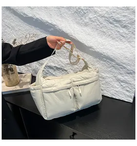Détail du sac fourre-tout matelassé beige en nylon avec poches avant zippées et latérale