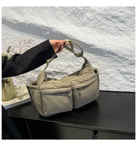 Vue détaillée du tissu en nylon kaki et du design fonctionnel à poches multiples du sac