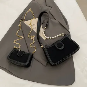 Sac bandoulière noir chic avec bandoulière perle et détails de chaîne dorée
