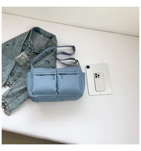 Détail du sac bandoulière en nylon bleu avec double poches zippées et sangle réglable